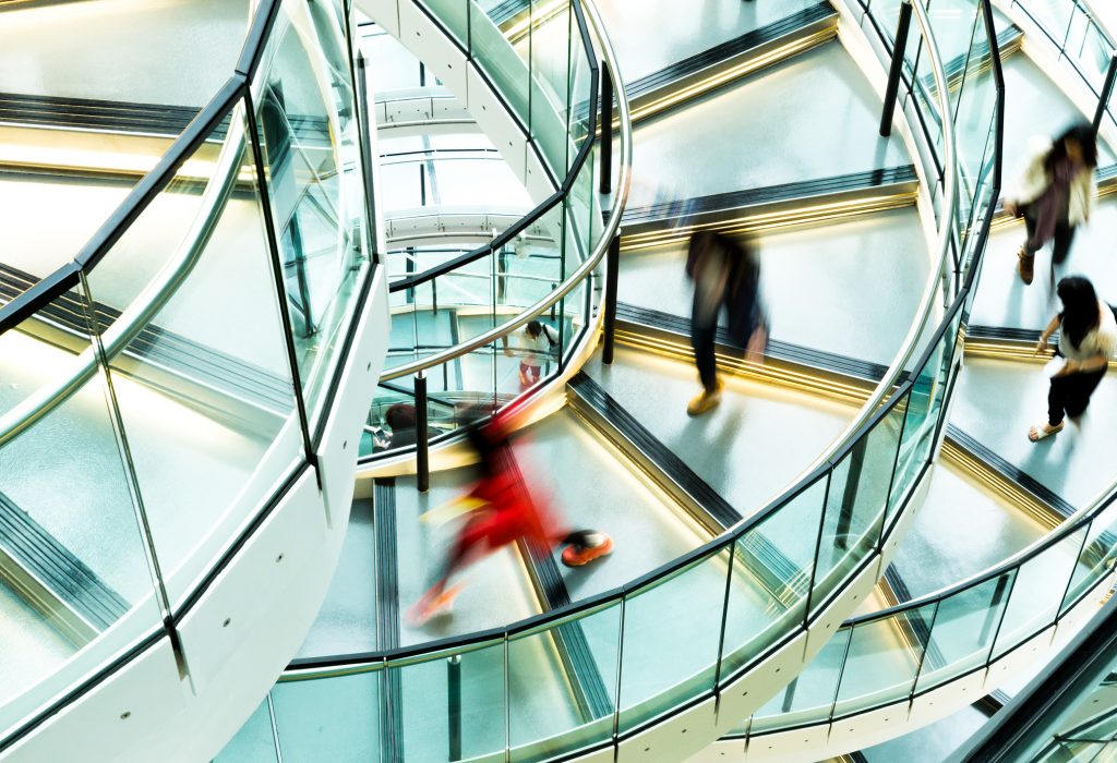 Motion blur of people on a contemporary spiral staircase.