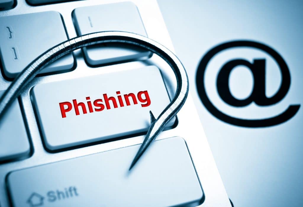 phishing / a fish hook on computer keyboard with email sign / computer crime / data theft / cyber crime